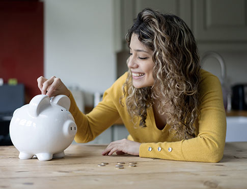 Woman putting spare change into piggy bank
