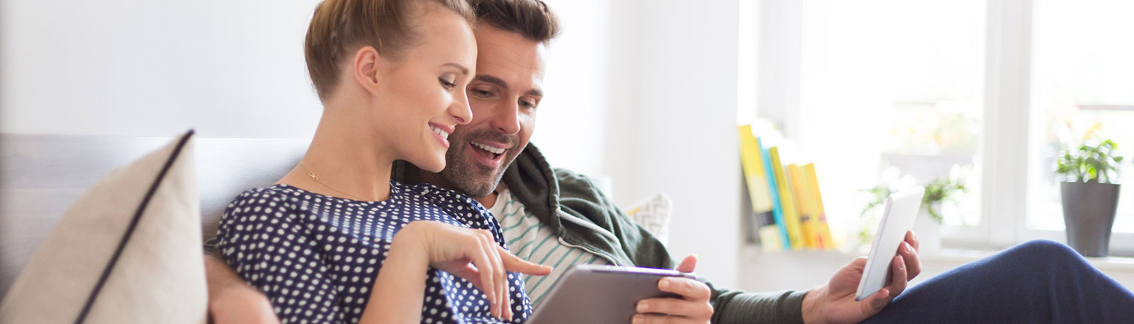 Young couple using phone in living room