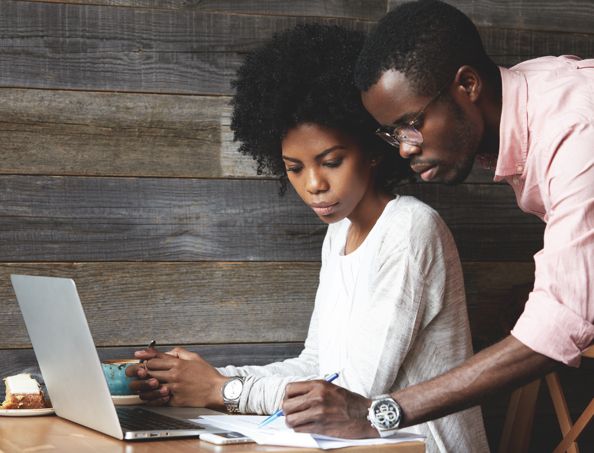 couple looks at paper near computer
